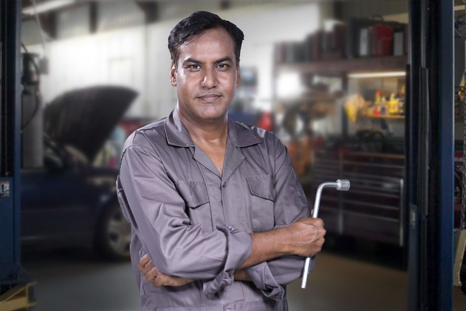 Friendly auto glass mechanic inspecting a vehicle window